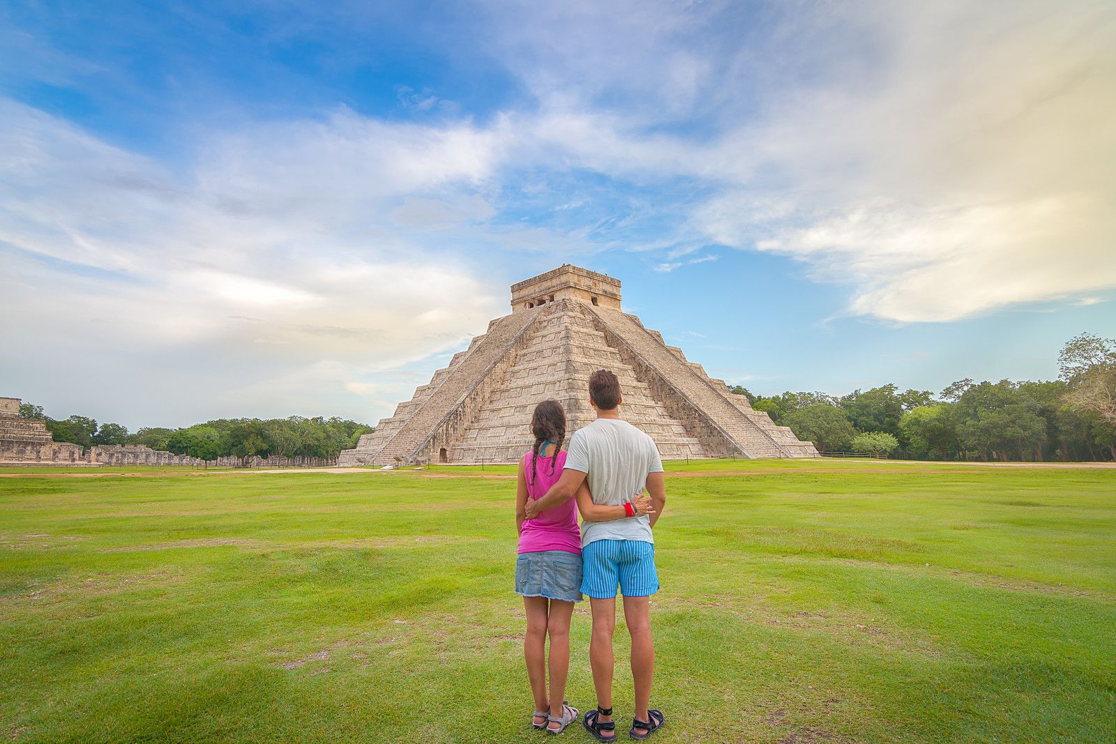 Hombre y mujer de pie cerca de la ruina maya