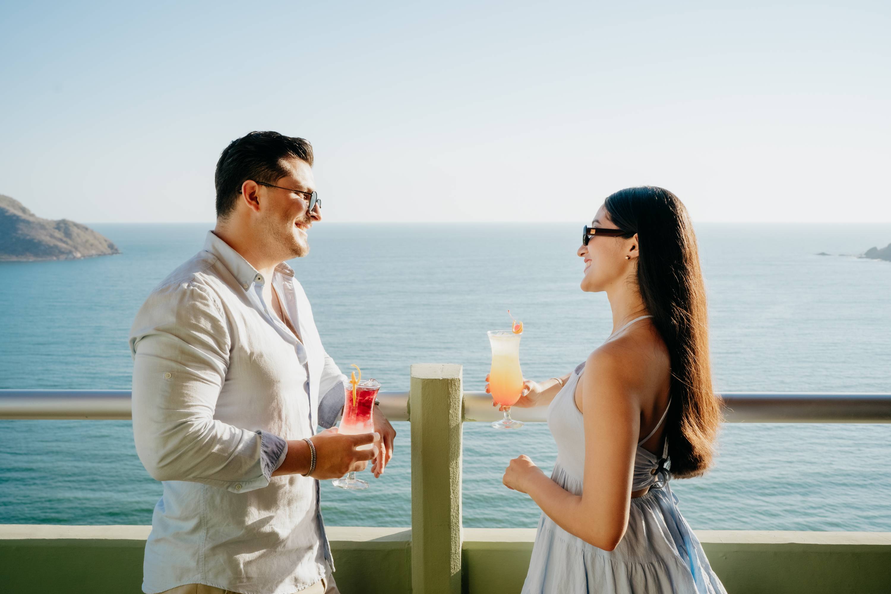 Couple enjoying cocktails with an ocean view.