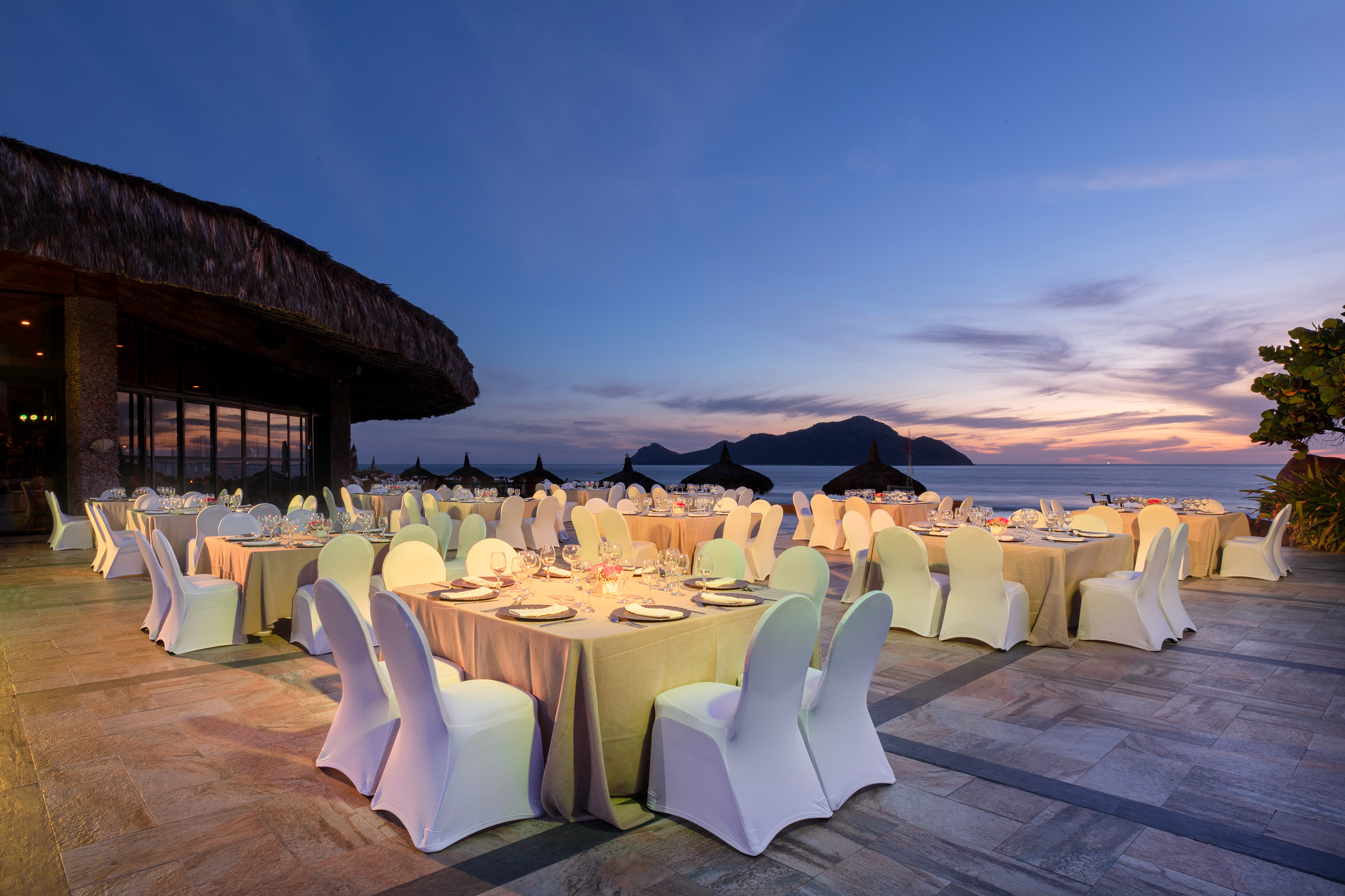 Outdoor private dinner setup overlooking the Pacific Ocean at sunset in Mazatlán.